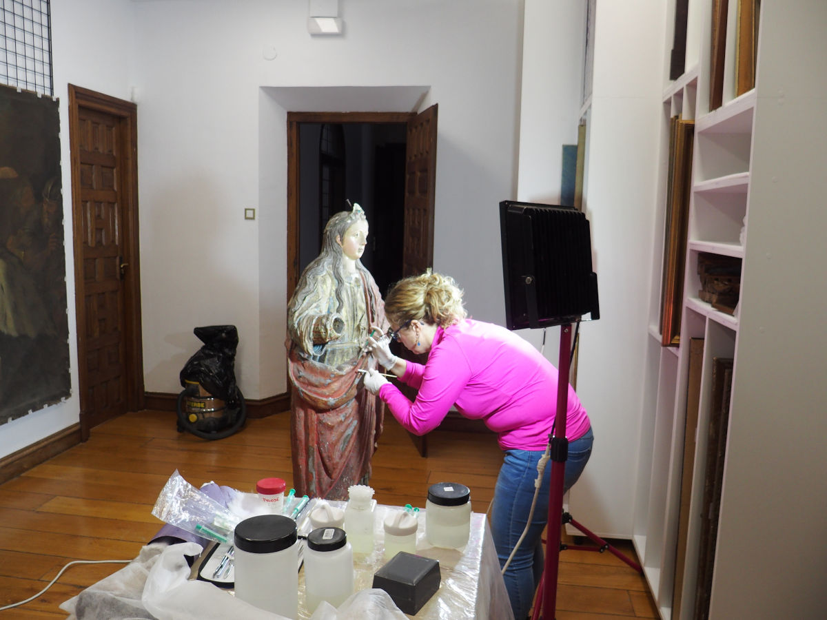 Restauradora aplicando labores de conservación en la escultura de Santa Barbararen
